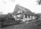 Bäuerin bei der Blumenpflege vor ihrem strohgedeckten Bauernhaus des 17./18. Jahrhunderts auf der Frankenalb bei Poppberg im Landkreis Sulzbach-Rosenberg. Vom malerischen Haus ist leider nur diese Fotografie von 1900 geblieben.