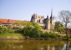 Schloss mit spitzen Türmen mit Fluss